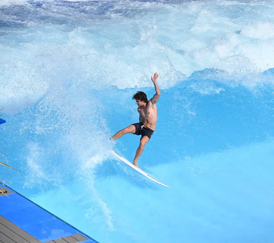 Fortgeschrittener Surfer bei einem kraftvollen Turn auf der künstlichen Welle von irie surf – Actionshot im Wellenpark für Advanced Surfer